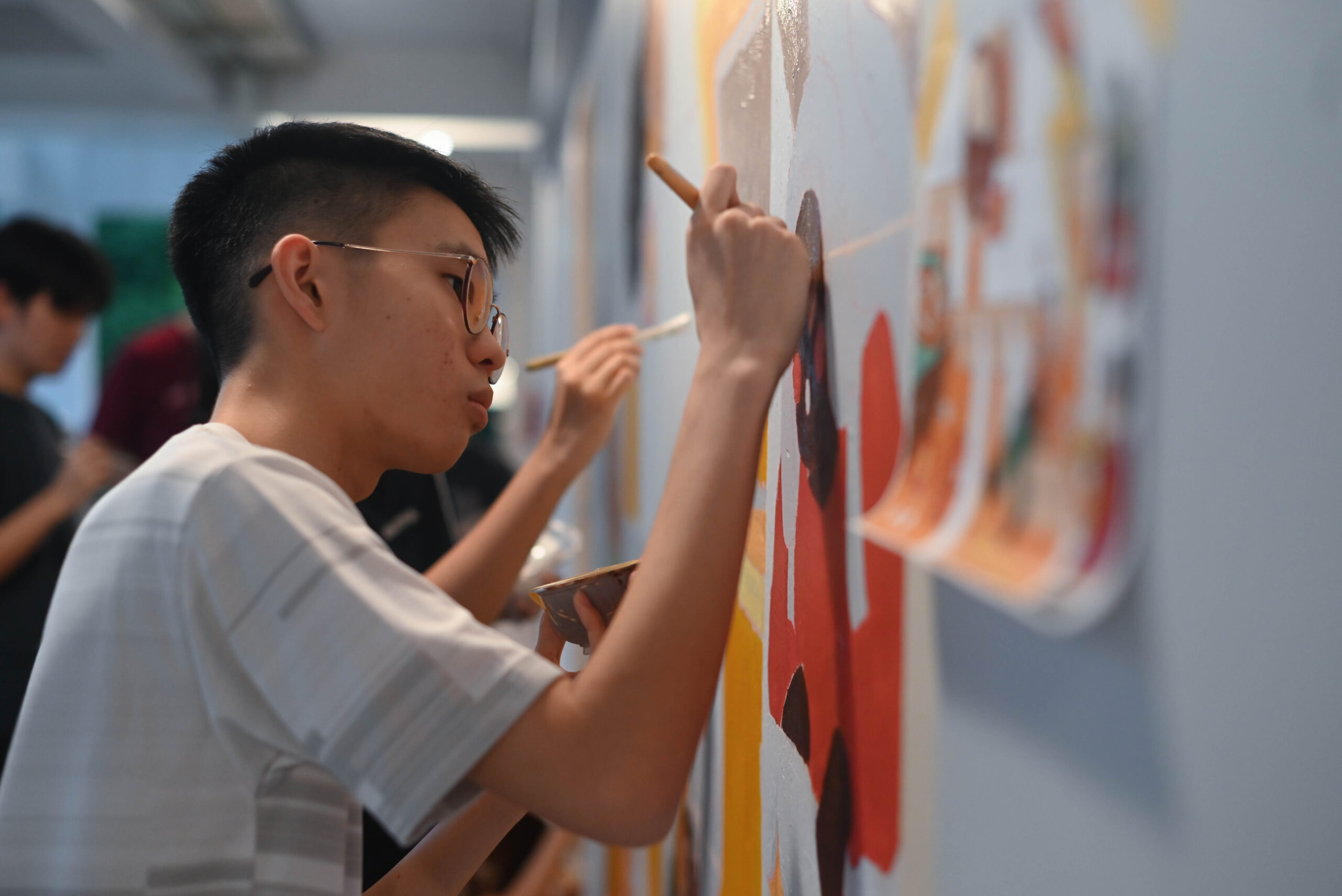 Helixians fully focus on painting the mural